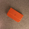 A duduk reed case for five reeds with a flap closure and a small embossed circular Dudukhouse logo, placed on a textured gray surface.