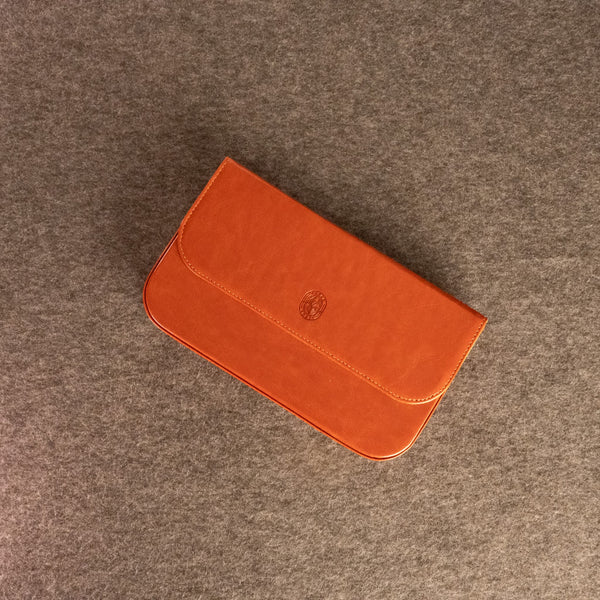 A duduk reed case for five reeds with a flap closure and a small embossed circular Dudukhouse logo, placed on a textured gray surface.